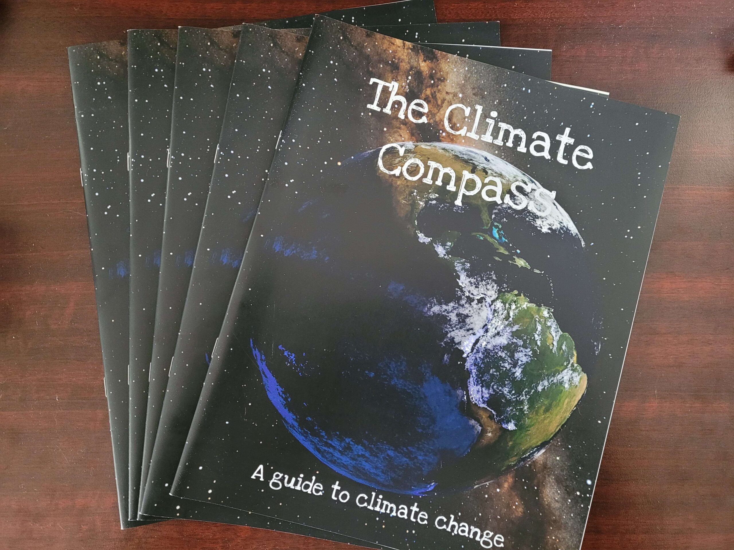 A stack of magazines titled The Climate Compass